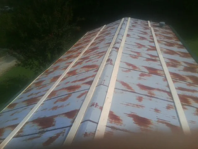 Rusted metal roof panels with new wood purlins before replacement — Storm Damage Roof Repair in Soledad by Roofing Brothers