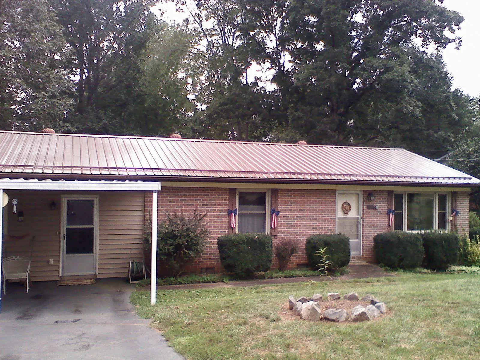 Bronze metal roof and carport on a brick ranch home — Roof Repair work by our crew in Soledad